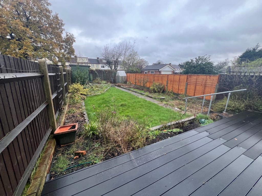 Decking leading to laid lawn with path to rear gar