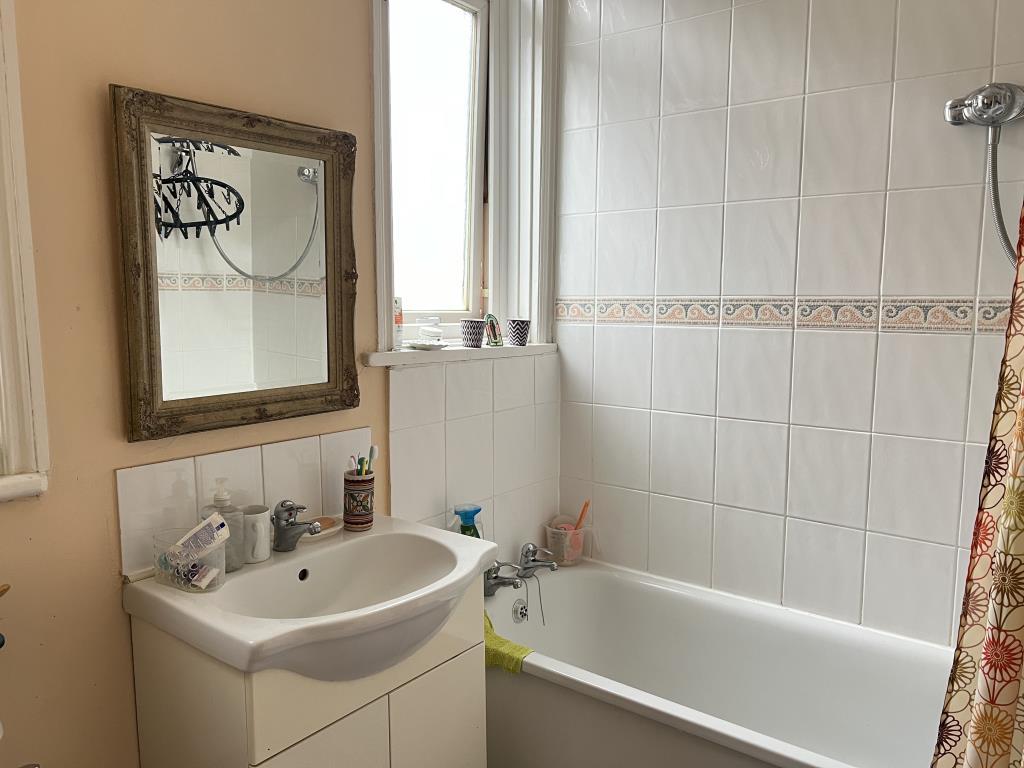 Bathroom with white suite and white wall tiles