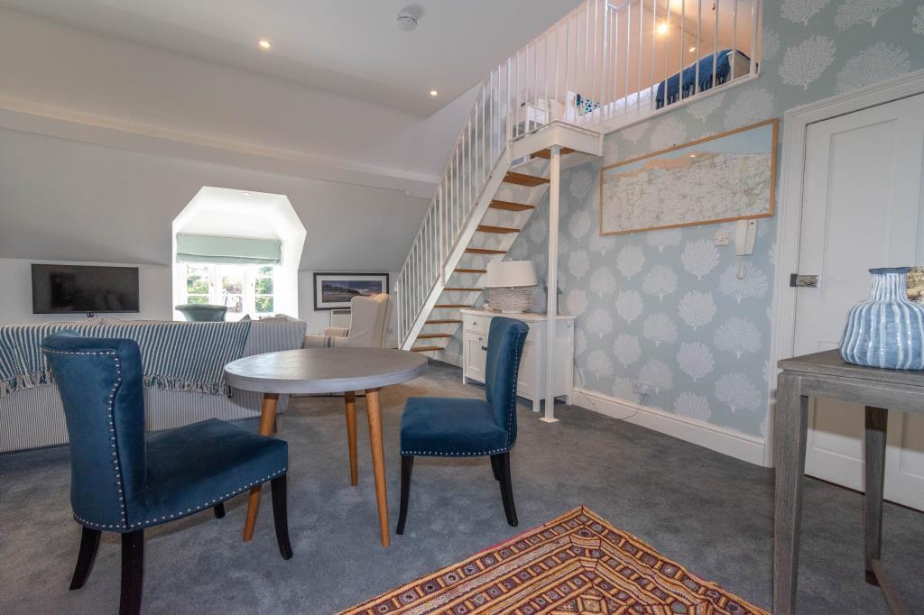 Living room with window to front and stairs to gal