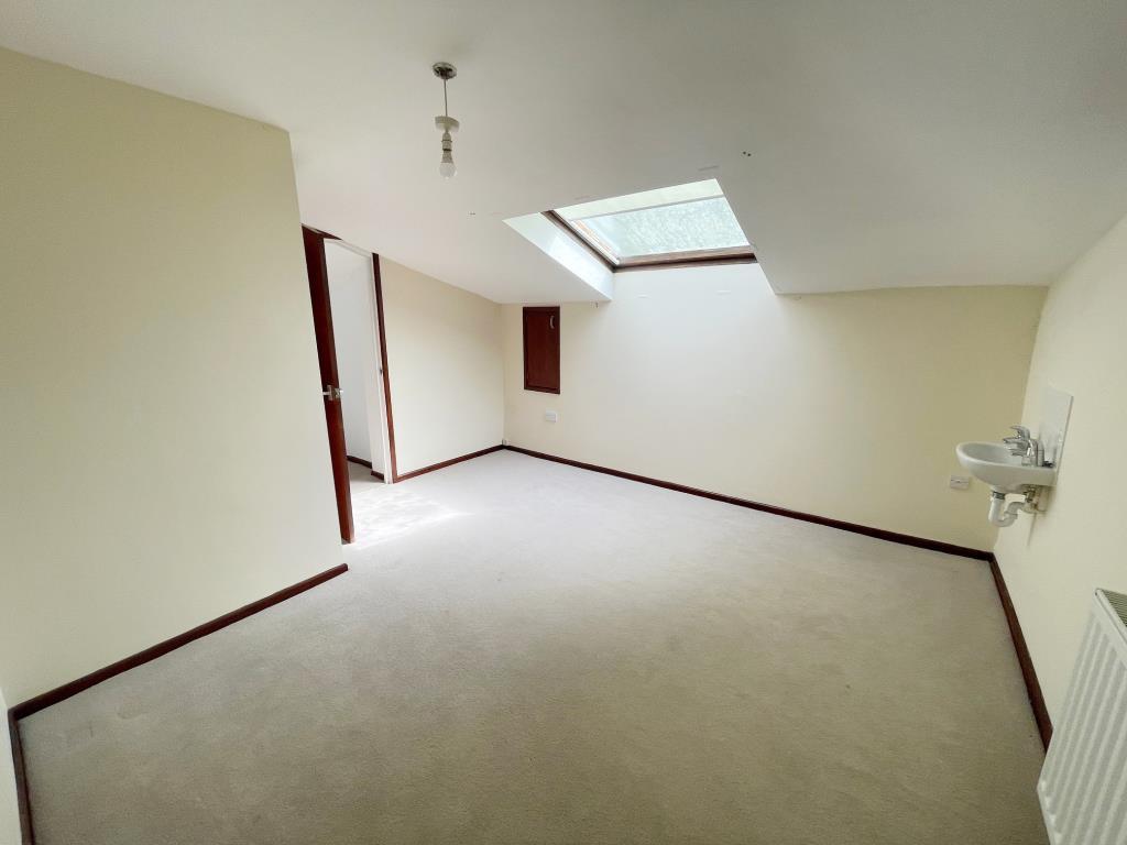 Main bedroom with skylight window sink and radiato