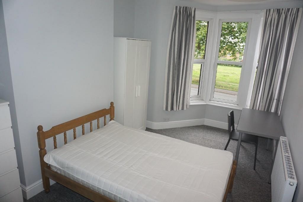 A bright and inviting double bedroom with ample...