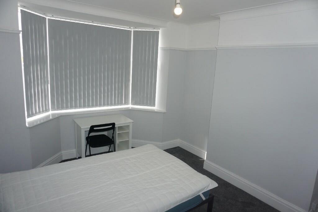 A bright and clean double bedroom with a comfor...