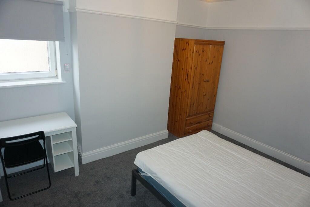 A tidy and inviting double bedroom with a fitte...