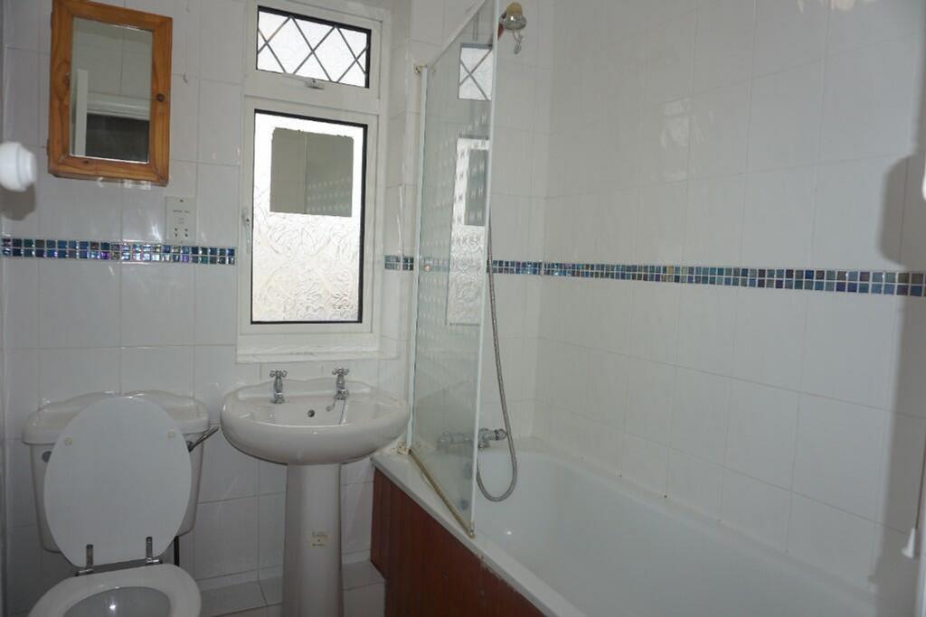 A tidy and functional bathroom featuring a bath...