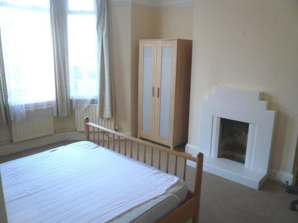 A spacious and bright double bedroom featuring ...