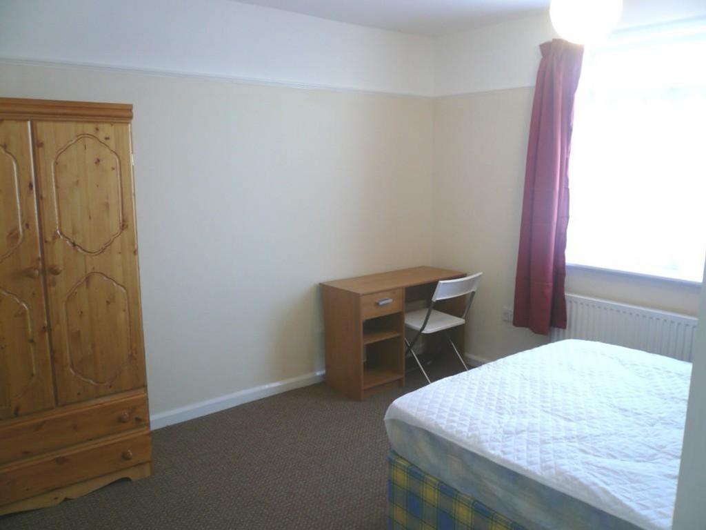 A spacious and well lit double bedroom equipped...