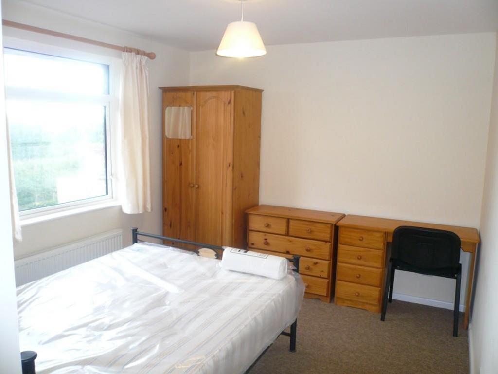 A spacious and well lit double bedroom featurin...