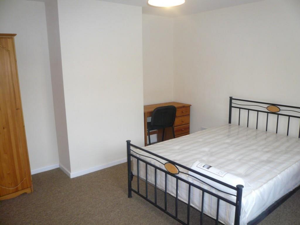 A spacious and tidy double bedroom featuring a ...