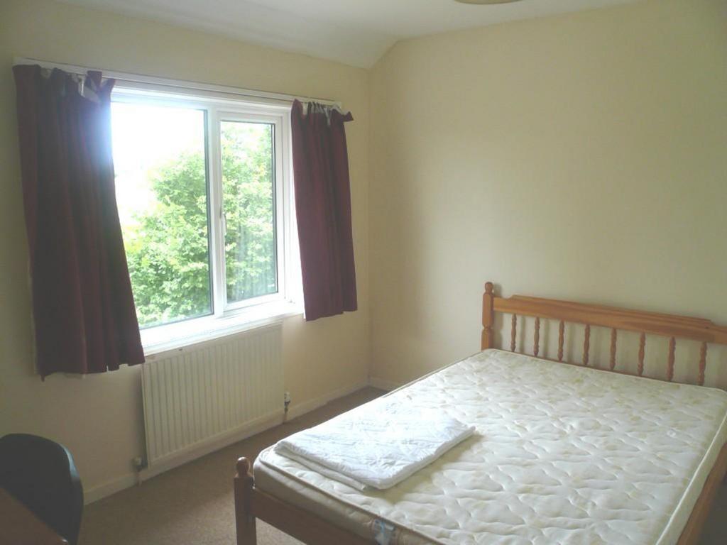 A bright and welcoming double bedroom with larg...