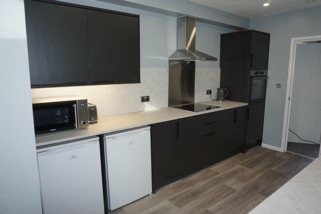 A modern and tidy kitchenette equipped with ess...