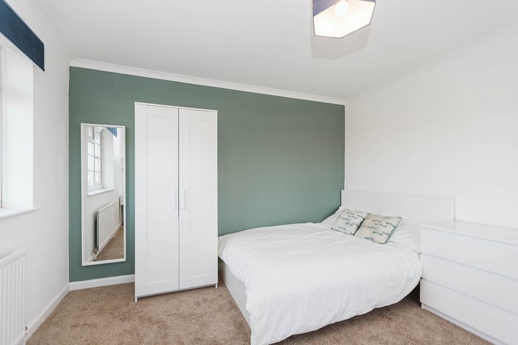 A spacious and inviting double bedroom featurin...