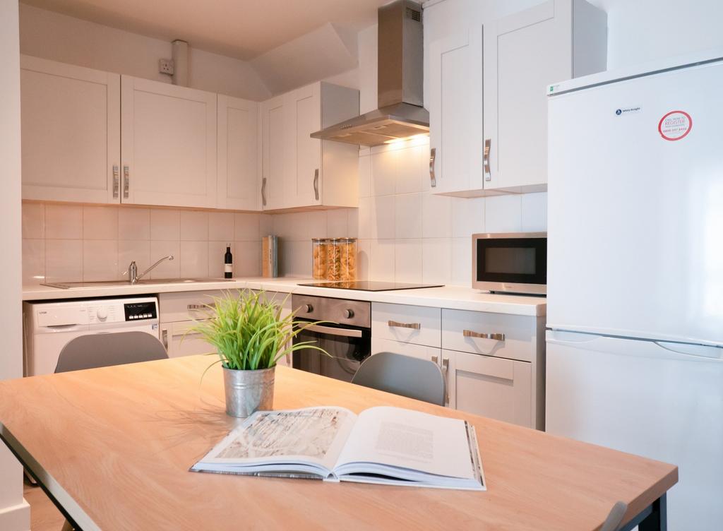 A bright and modern kitchen featuring ample sto...