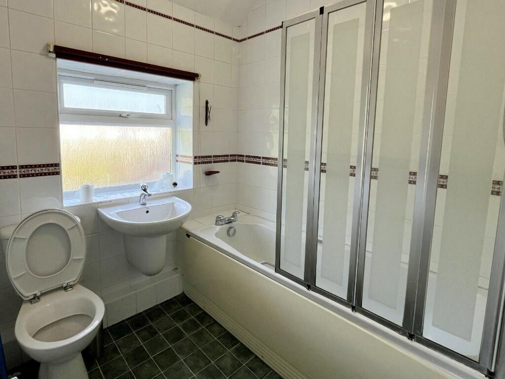 A clean and tidy bathroom featuring both a bath...