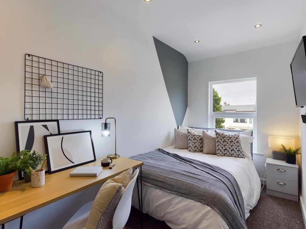 A bright and stylish double bedroom featuring a...