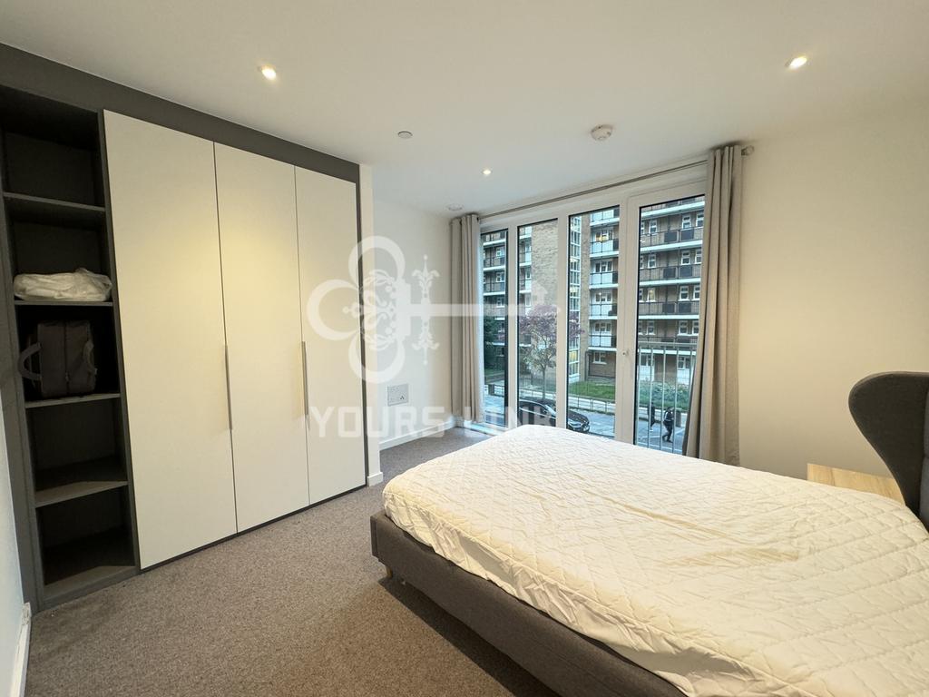 A spacious and well lit double bedroom featurin...