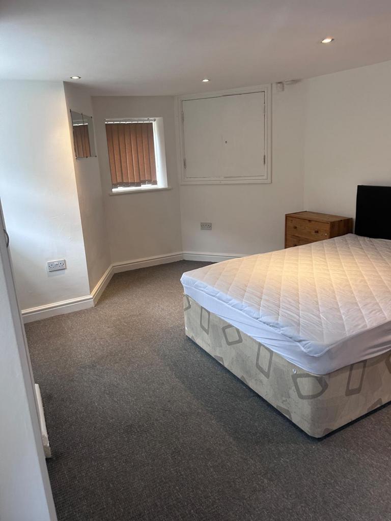 A spacious and inviting double bedroom with nat...