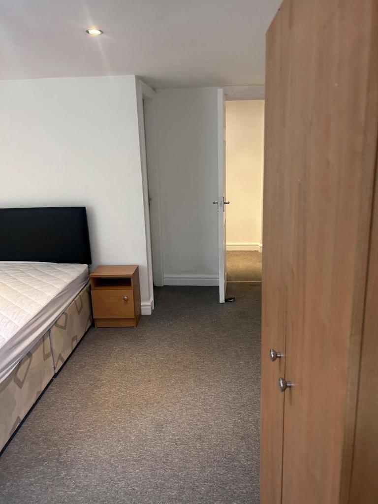 A spacious double bedroom with a comfortable la...