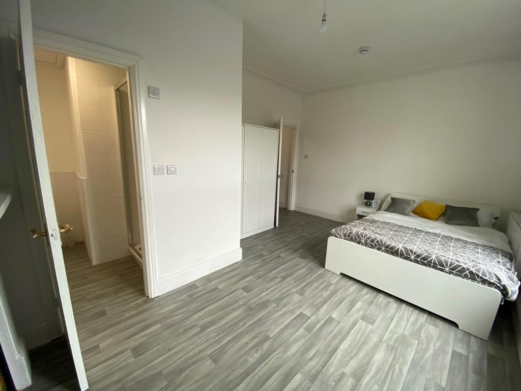 A spacious and well-lit double bedroom, perfect...