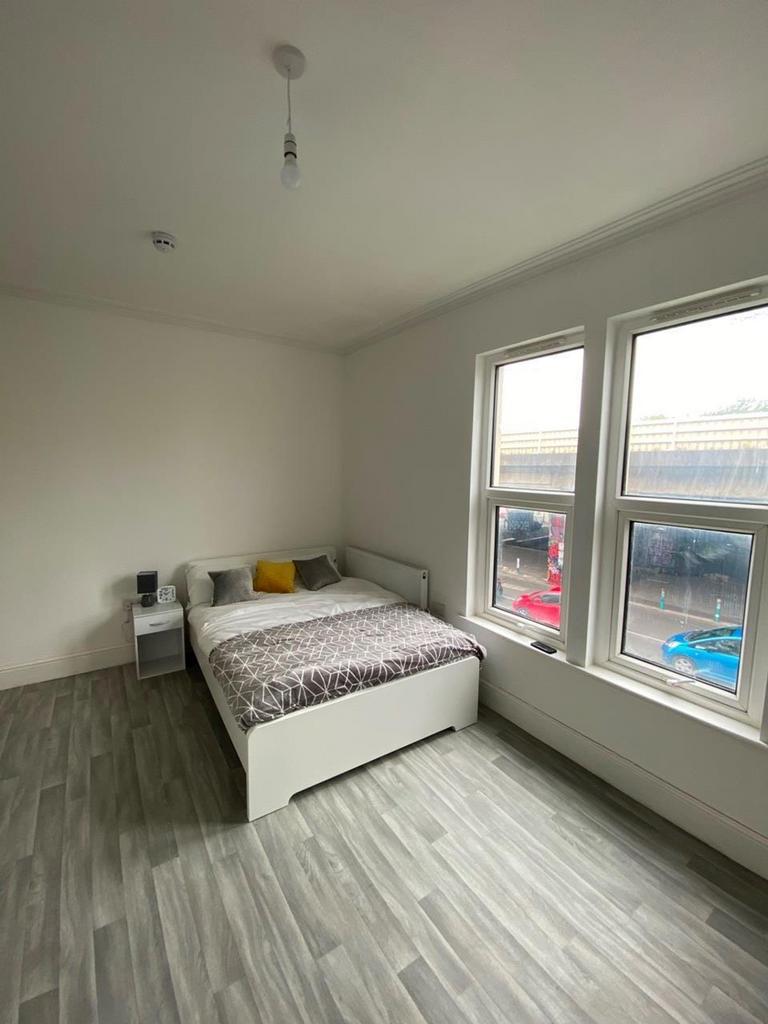 A bright and tidy double bedroom featuring larg...