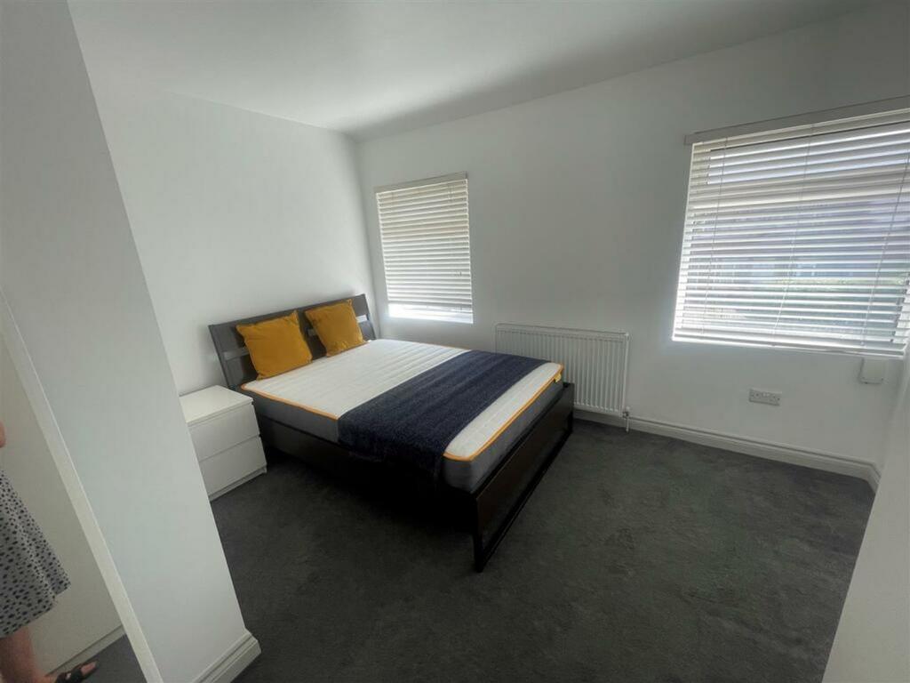 A tidy and well lit double bedroom featuring a ...