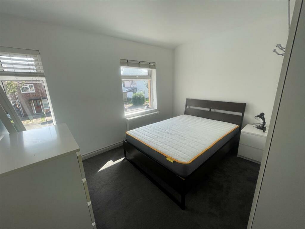 A clean and bright double bedroom with large wi...