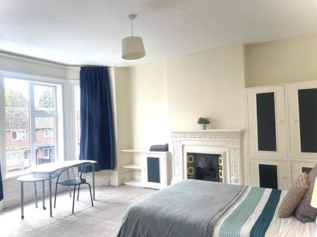 A spacious and bright double bedroom featuring ...