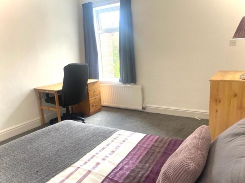 A spacious and well-lit double bedroom featurin...