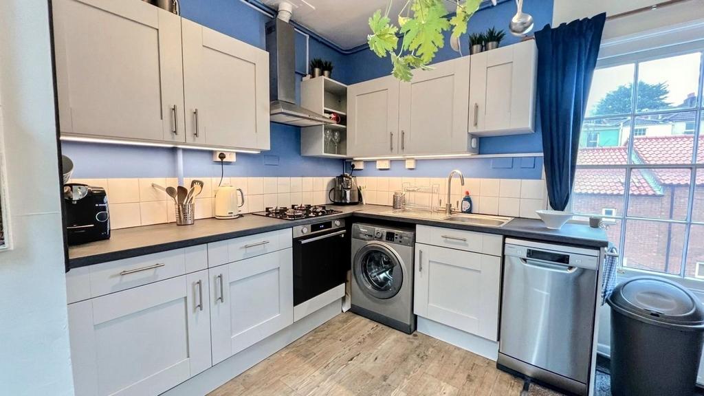 A modern and tidy kitchenette with ample storag...