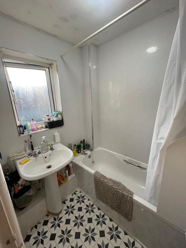 A well-equipped bathroom featuring a bathtub an...