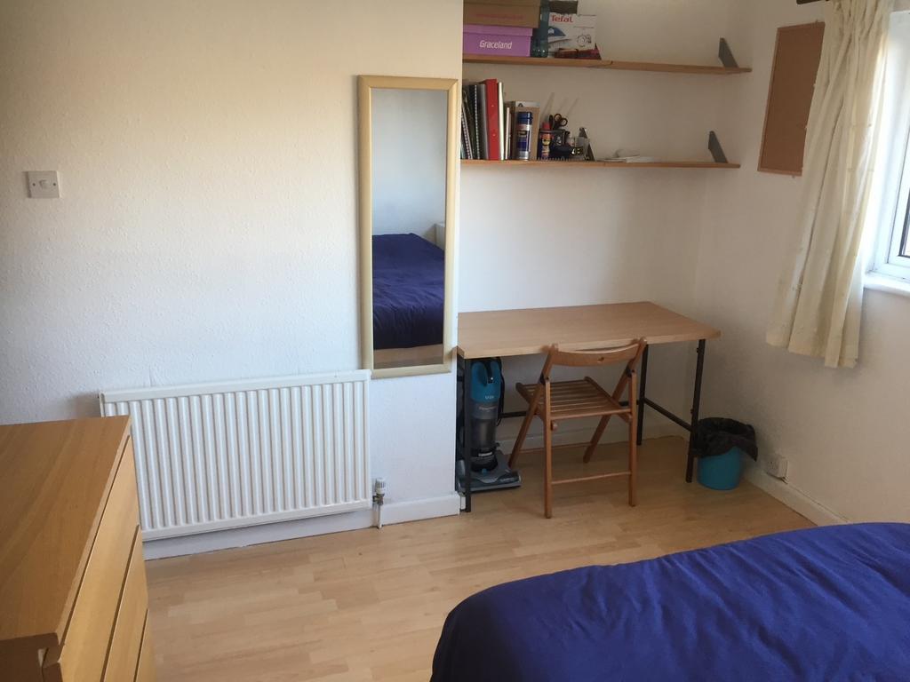 Bright, simply furnished bedroom with wooden fl...