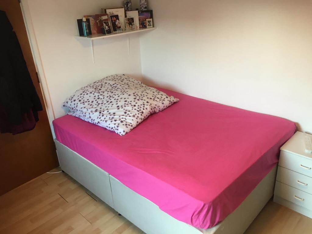 Bright, simply furnished bedroom with a double ...