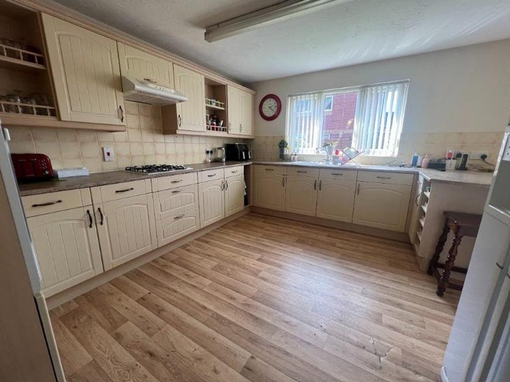 A spacious and bright kitchen with ample natura...