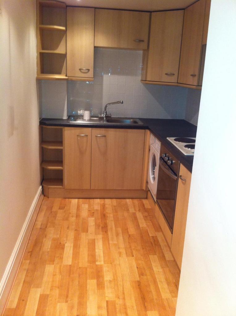 A tidy kitchenette featuring modern wooden cabi...