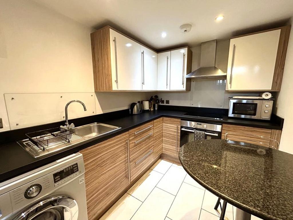 A modern and clean kitchenette with stylish cab...