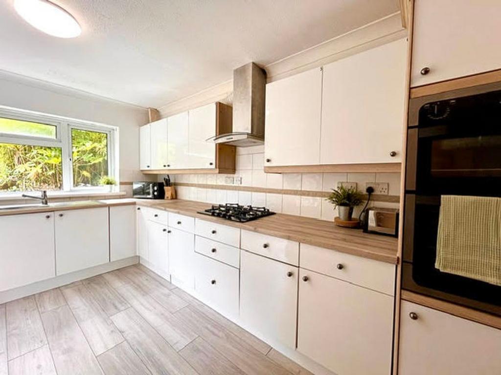 A bright and modern kitchen featuring ample sto...