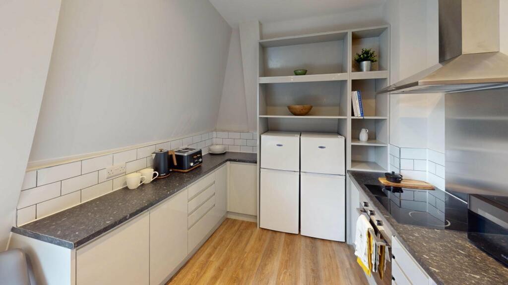 A modern and tidy kitchenette with ample storag...