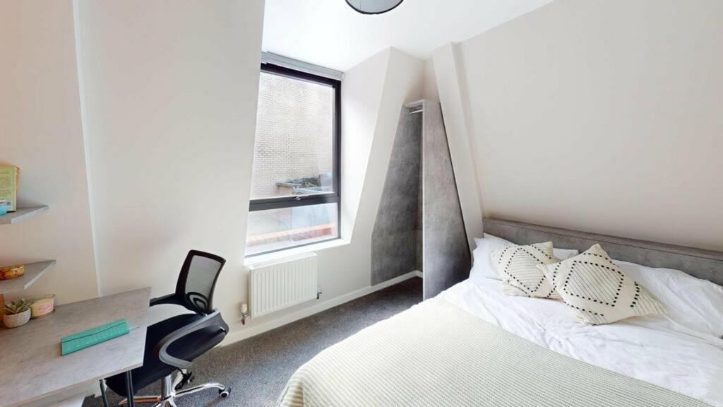 A bright and stylish double bedroom featuring a...