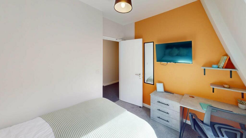 A bright and tidy double bedroom featuring mode...