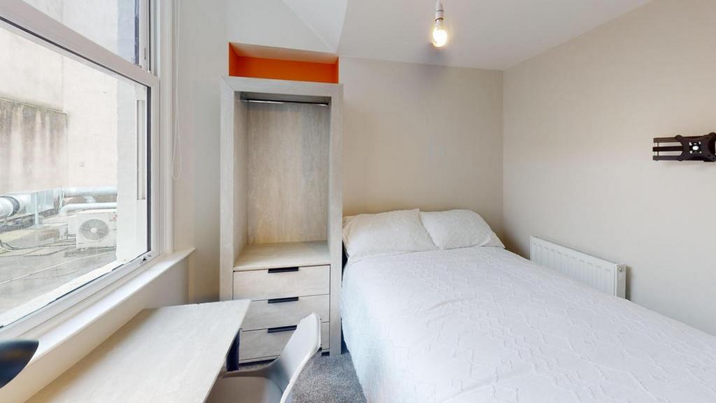 A bright and tidy double bedroom featuring a co...