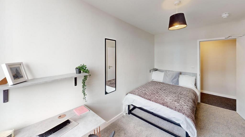 A bright and tidy double bedroom featuring mode...