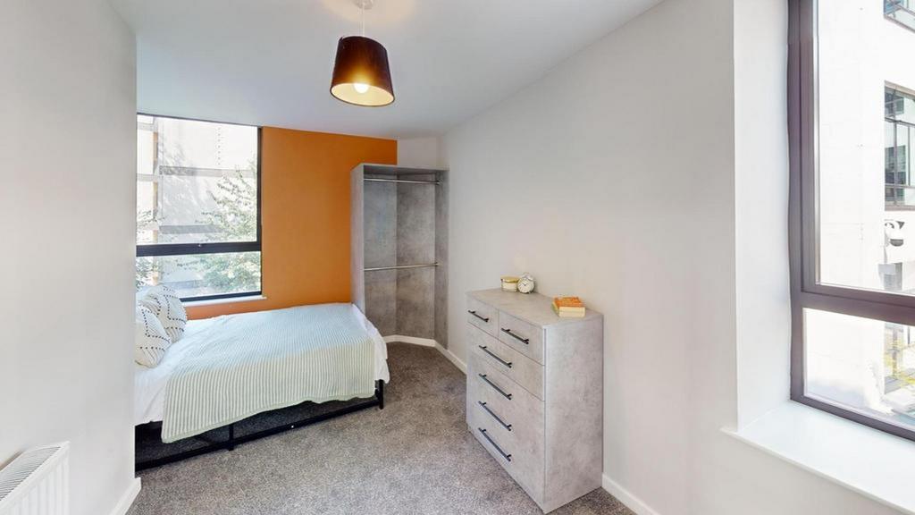 A bright and tidy double bedroom featuring mode...