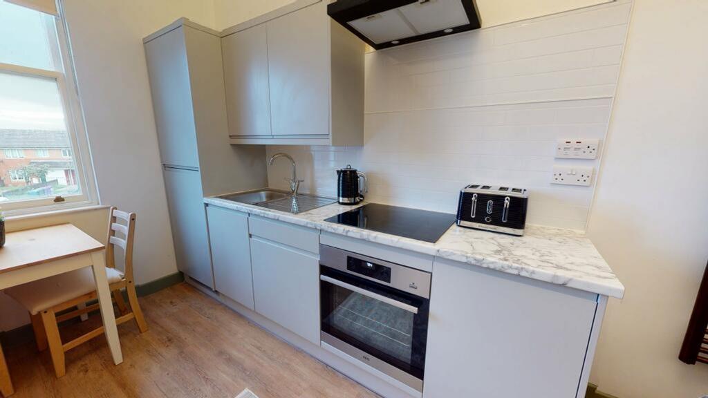 A modern and tidy kitchenette with plenty of na...