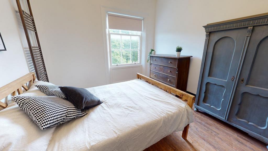 A cozy and well-lit double bedroom featuring st...