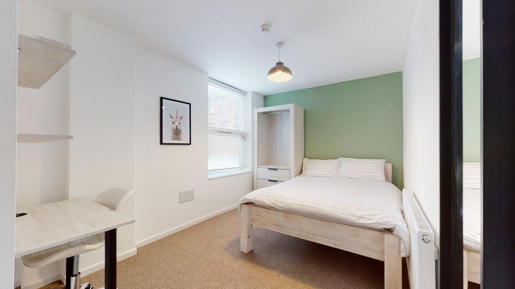 A bright and inviting double bedroom with a coz...