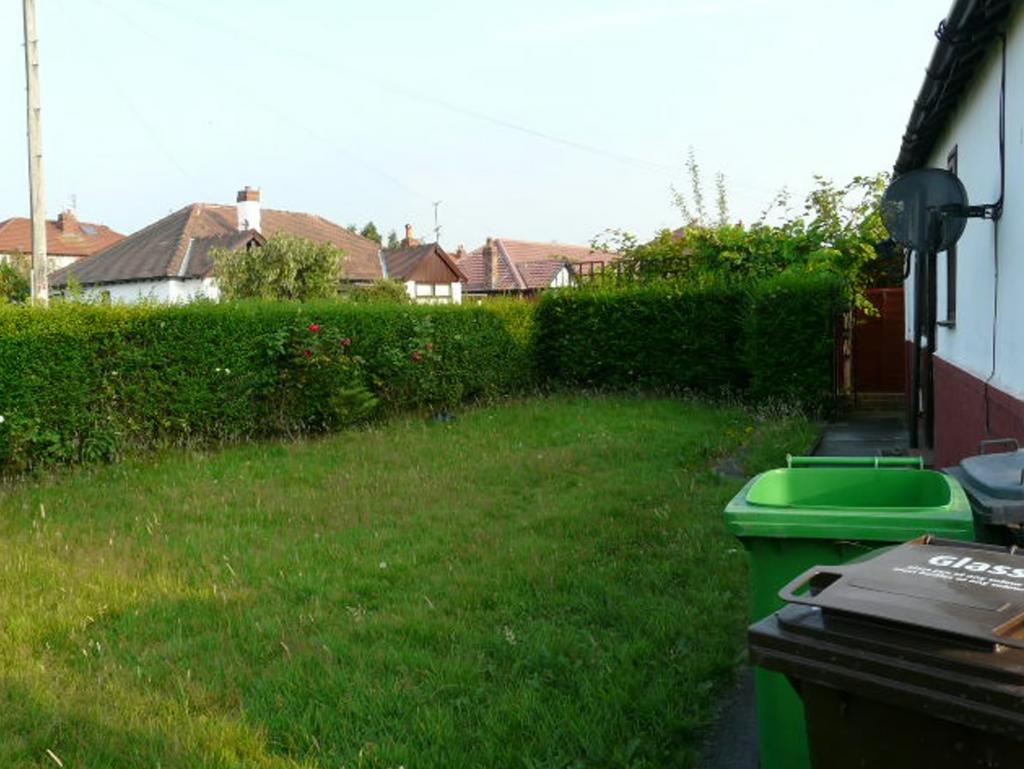 A spacious garden with well maintained hedges, ...