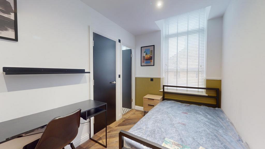 A bright and tidy double bedroom featuring a co...