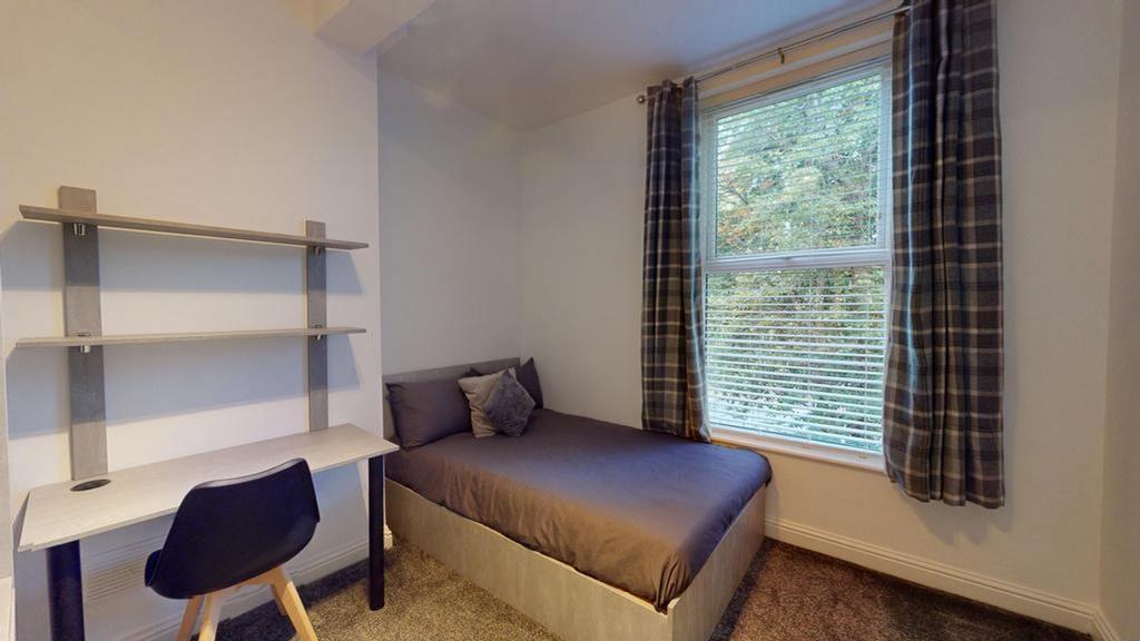 A bright and inviting double bedroom with a com...