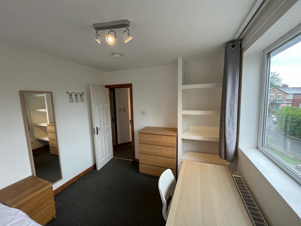 A spacious and well lit double bedroom with mod...