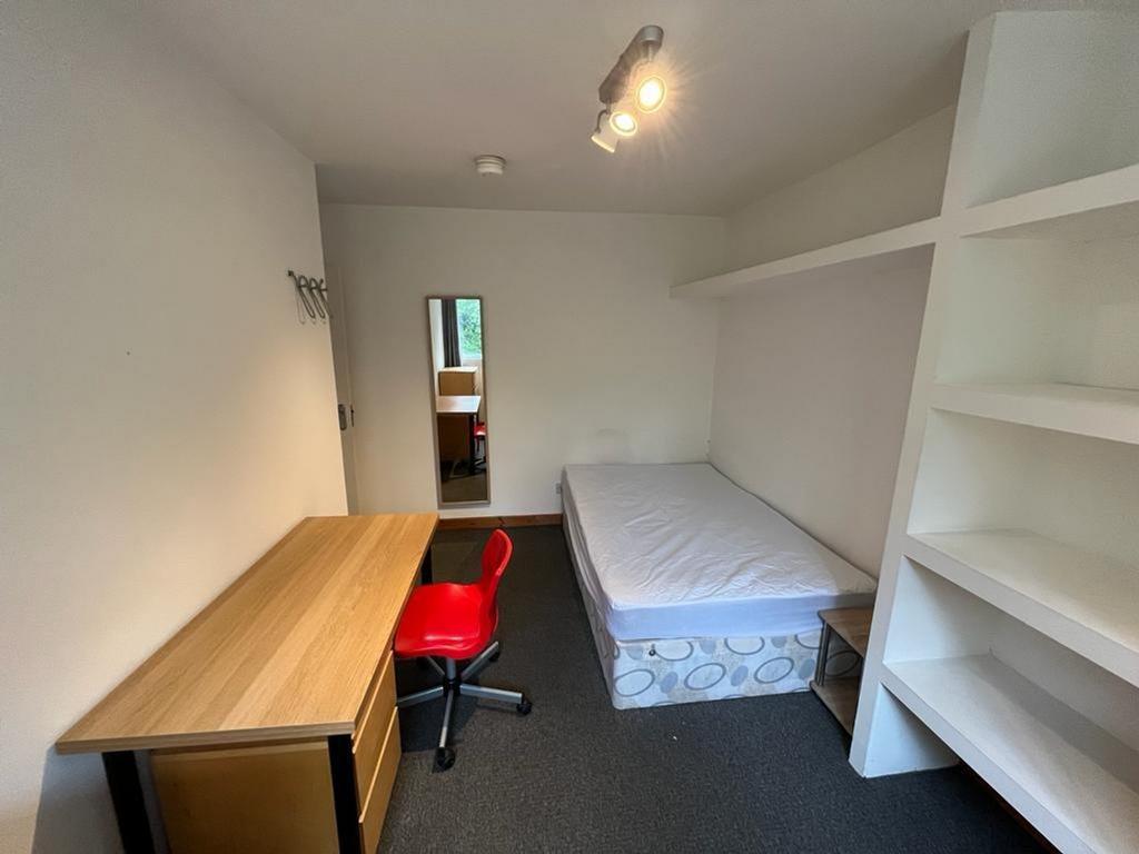 A spacious and tidy double bedroom featuring a ...