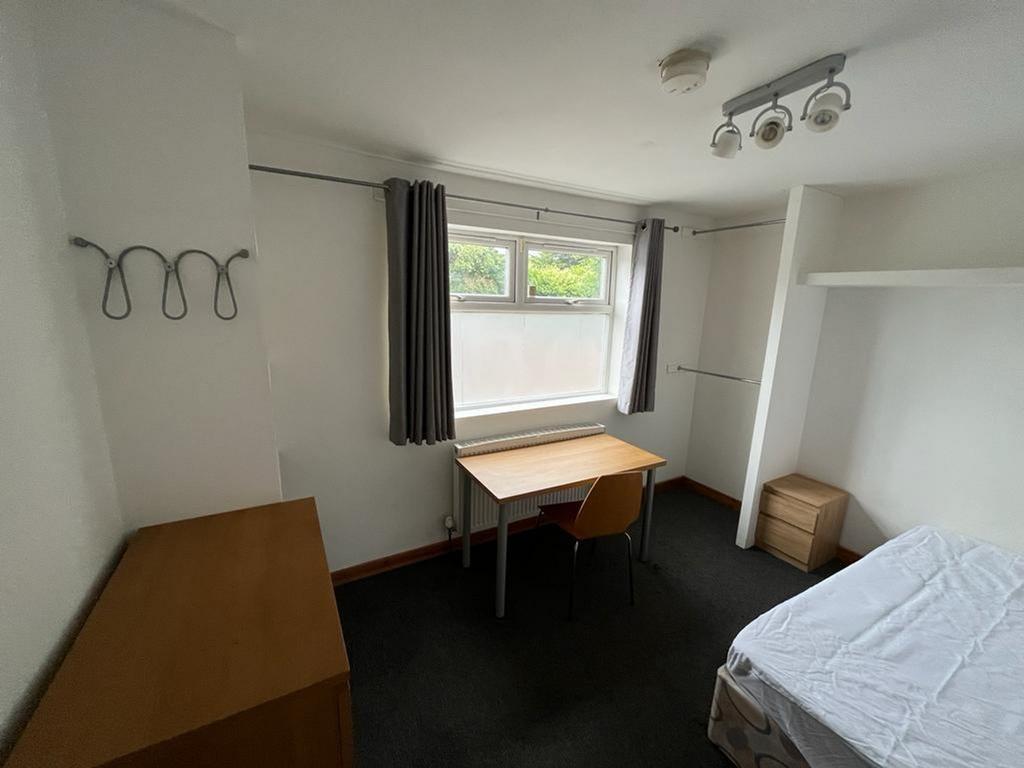 A bright and tidy double bedroom featuring a st...